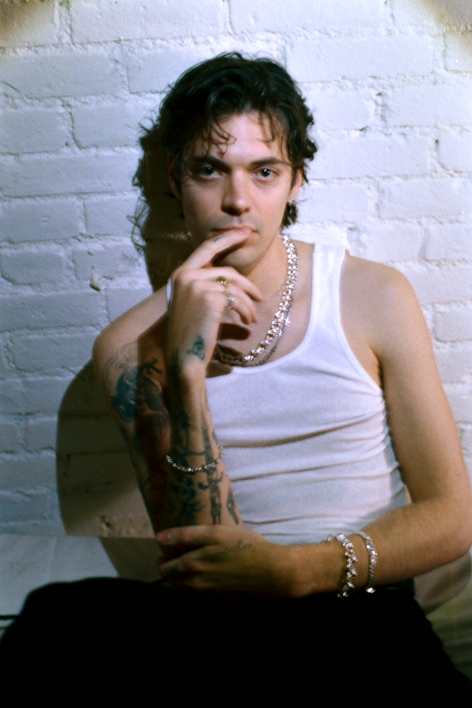 man in white tank top wearing silver jewelry 