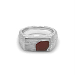 Silver ring with a red stone on a white background