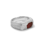 Silver ring with a red stone on a white background