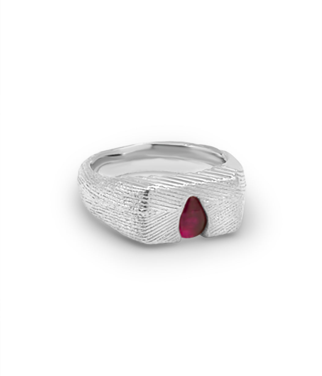 Silver ring with a red gemstone on a white background