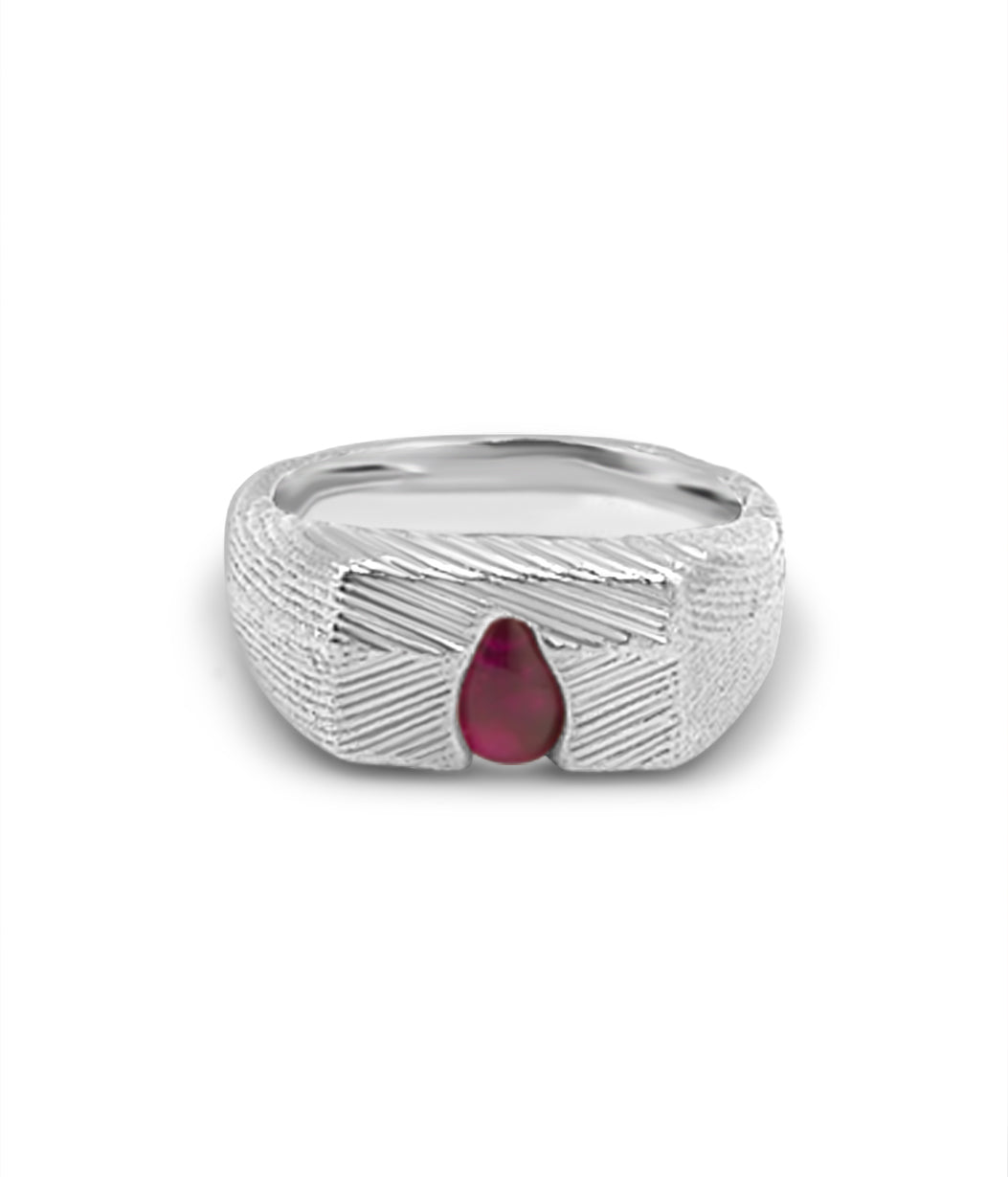 Silver ring with a red gemstone on a white background