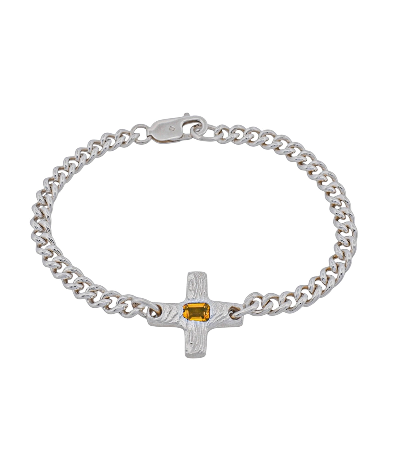 A silver chain bracelet with a textured cross charm featuring a small rectangular yellow gemstone, shown on a plain white background.