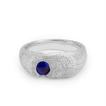 Silver ring with a blue gemstone on a white background