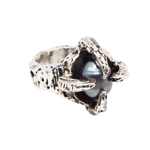 Silver ring with a central pearl on a white background