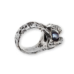 Silver ring with a central gemstone on a white background