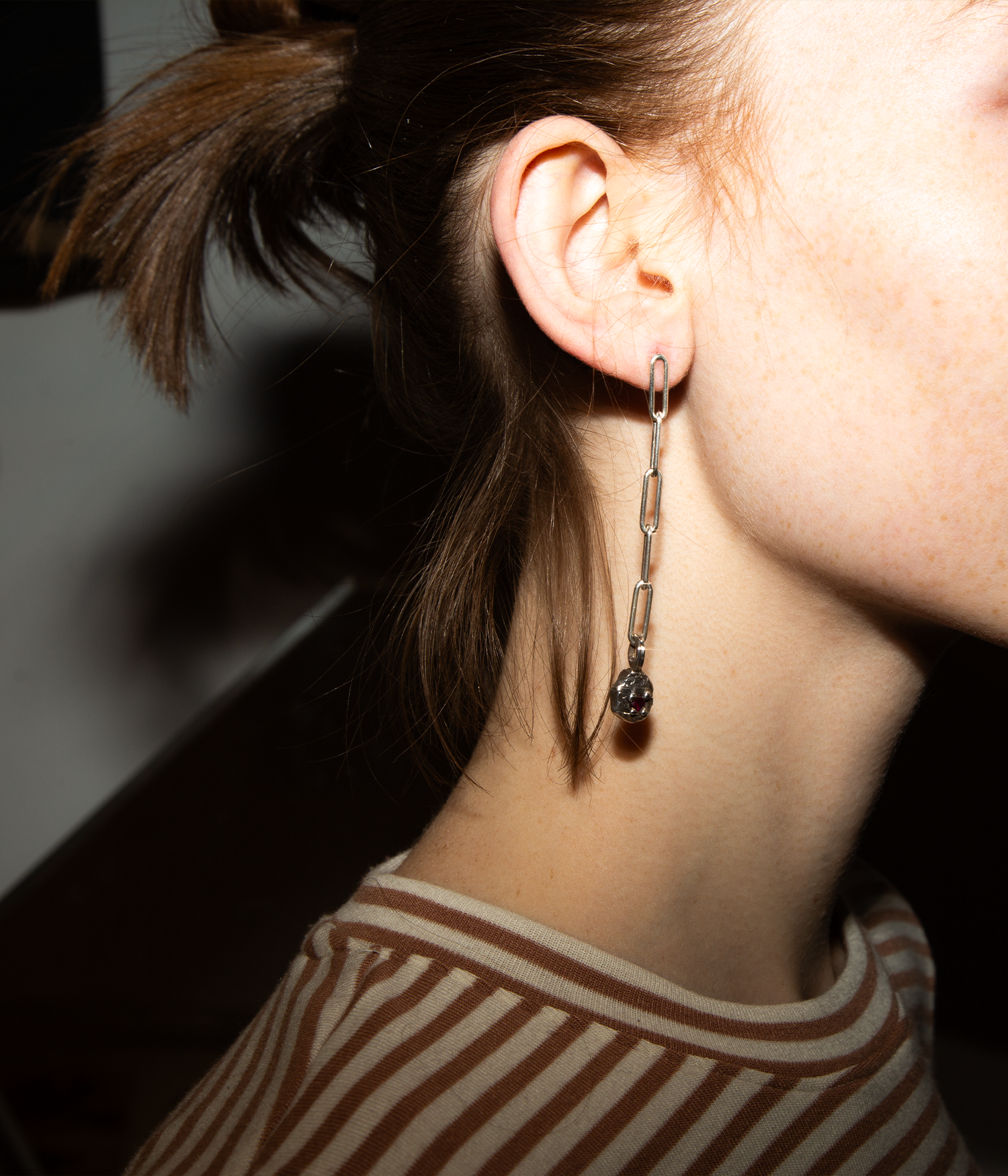 Close-up of an earring worn by a person with a blurred background