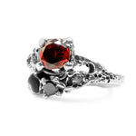 Silver ring with a red gemstone on a white background