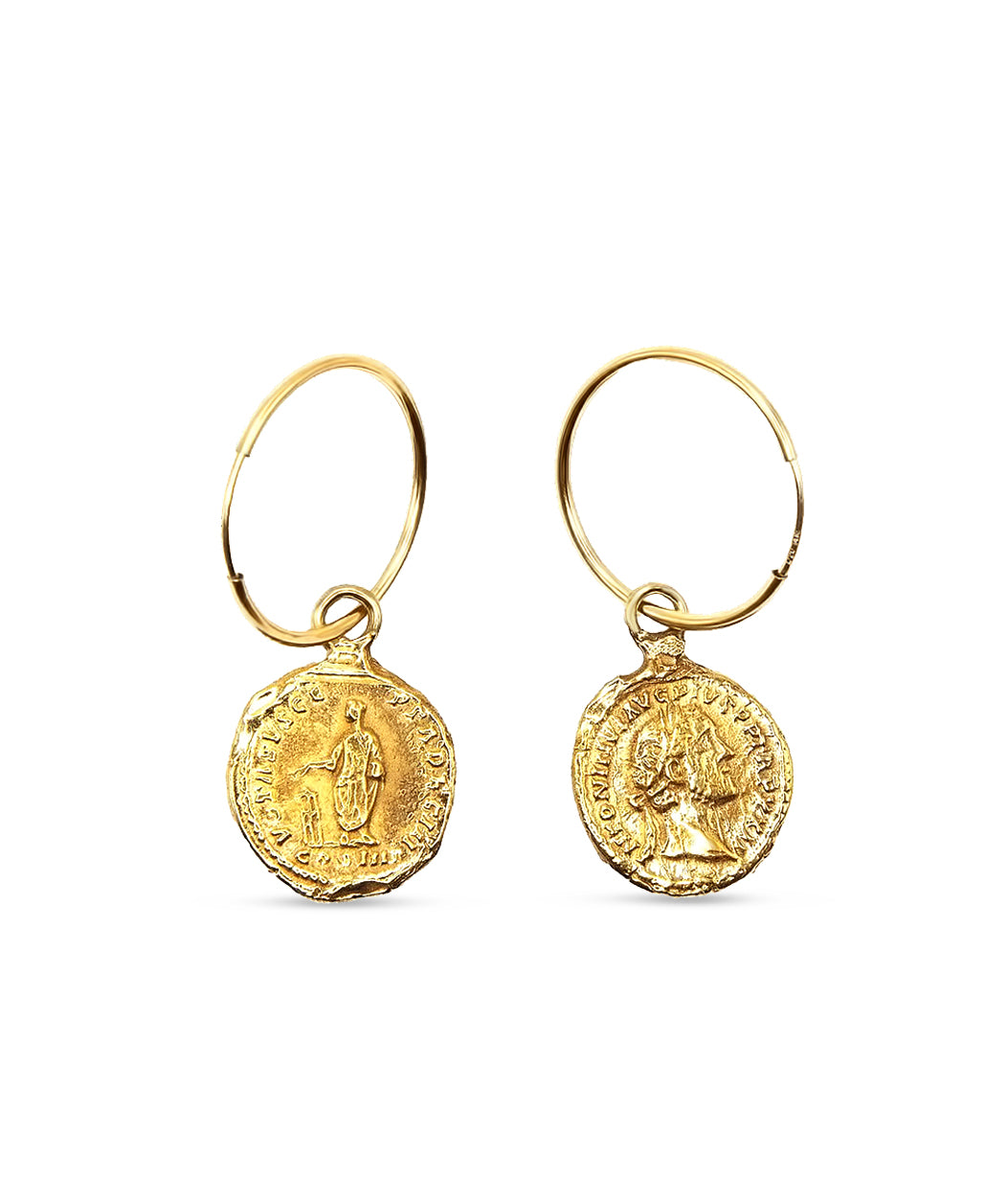 Gold earrings with coin-like pendants on a white background