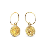 Gold earrings with coin-like pendants on a white background