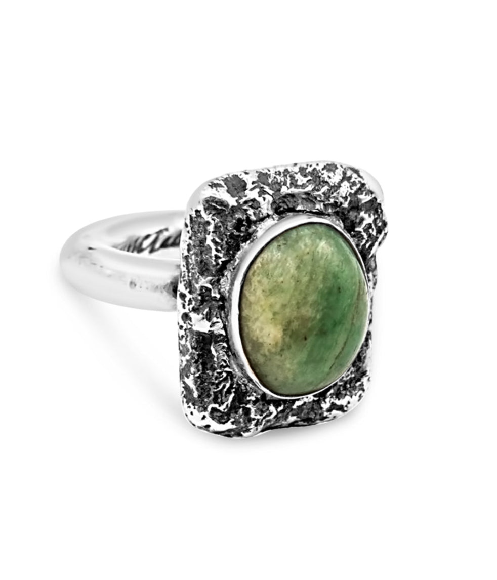 Silver ring with a green stone on a white background