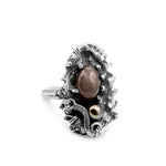 Silver ring with a central brown stone on a white background