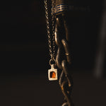 Necklace with a pendant hanging from a chain against a dark background