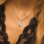 Necklace with a pendant worn by a person in a black lace garment