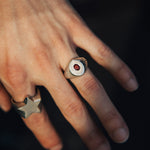 Close-up of a hand wearing two rings with a dark background