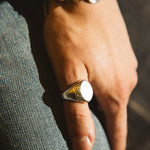 Hand wearing a ring with a blurred background