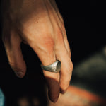 Hand wearing a ring with a blurred background