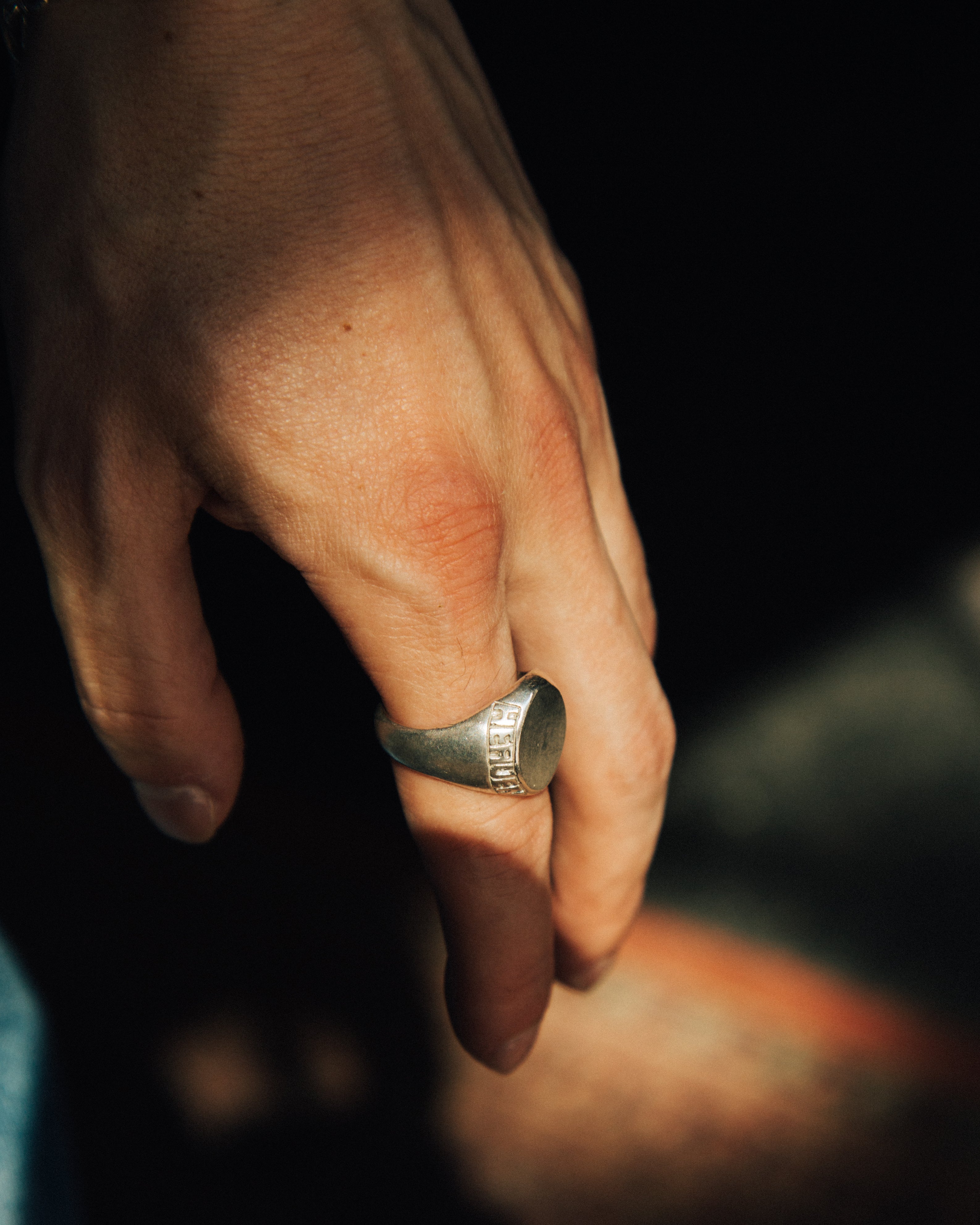 Hand wearing a ring with a blurred background