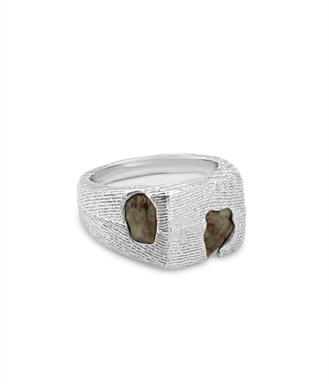 Silver ring with embedded stones on a white background