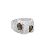 Silver ring with embedded stones on a white background