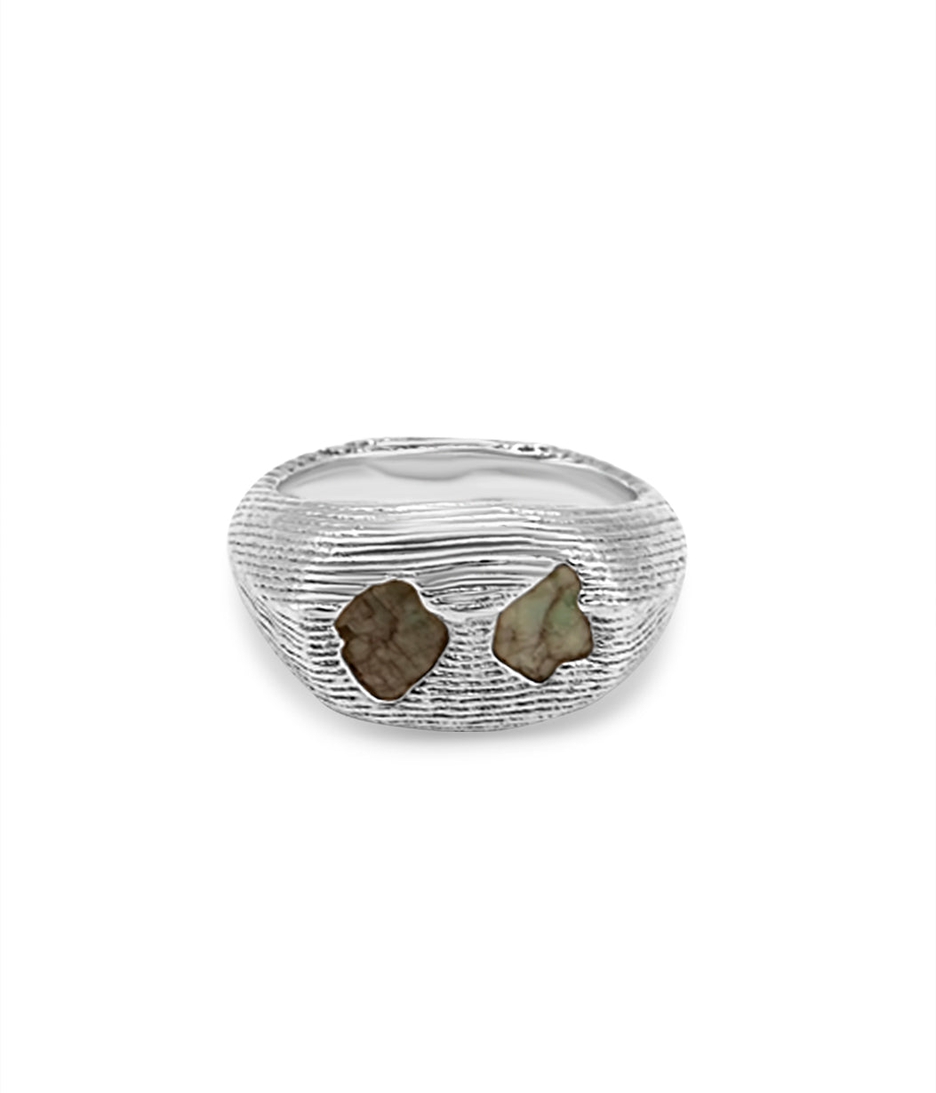 Silver ring with embedded stones on a white background