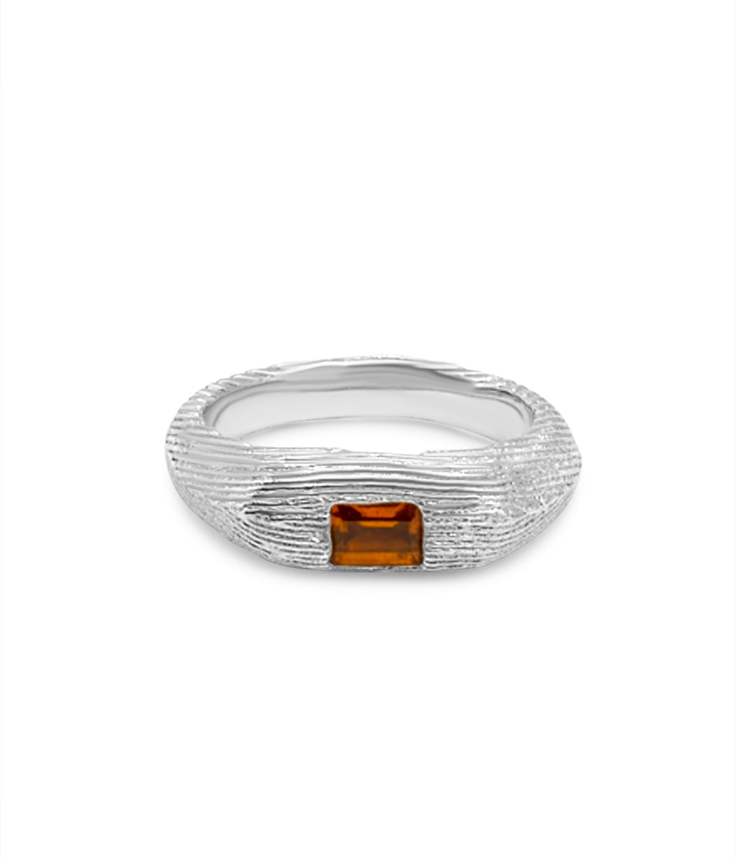 Silver ring with a rectangular brown gemstone on a white background