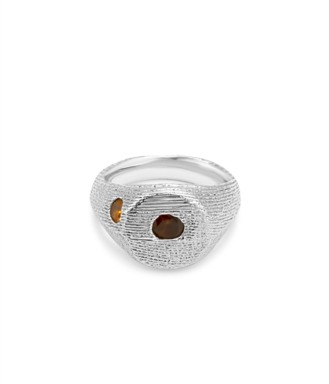 Silver ring with embedded stones on a white background