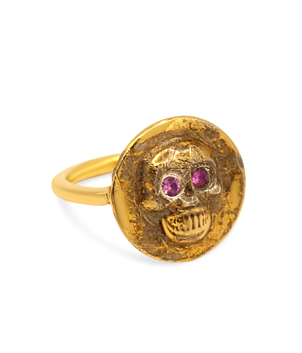 Gold skull ring with red gemstones on a white background