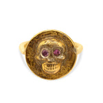 Gold skull ring with red gemstones on a white background
