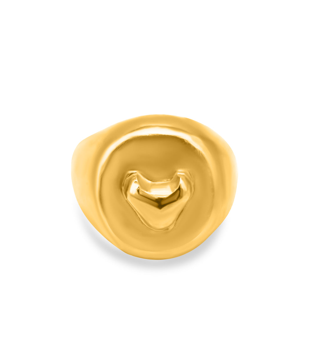 Gold ring with a heart design on a white background