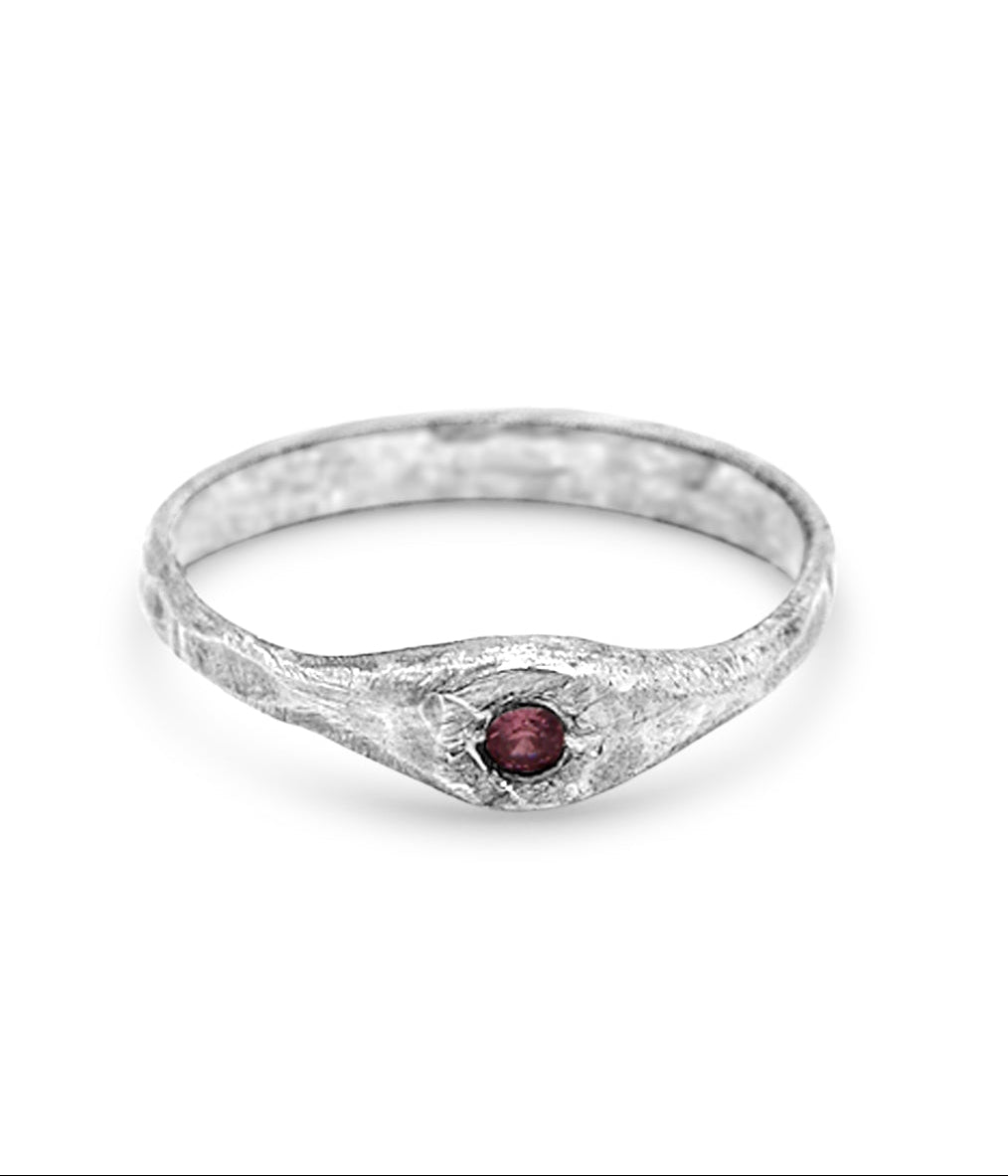 pink sapphire and silver ring on white background
