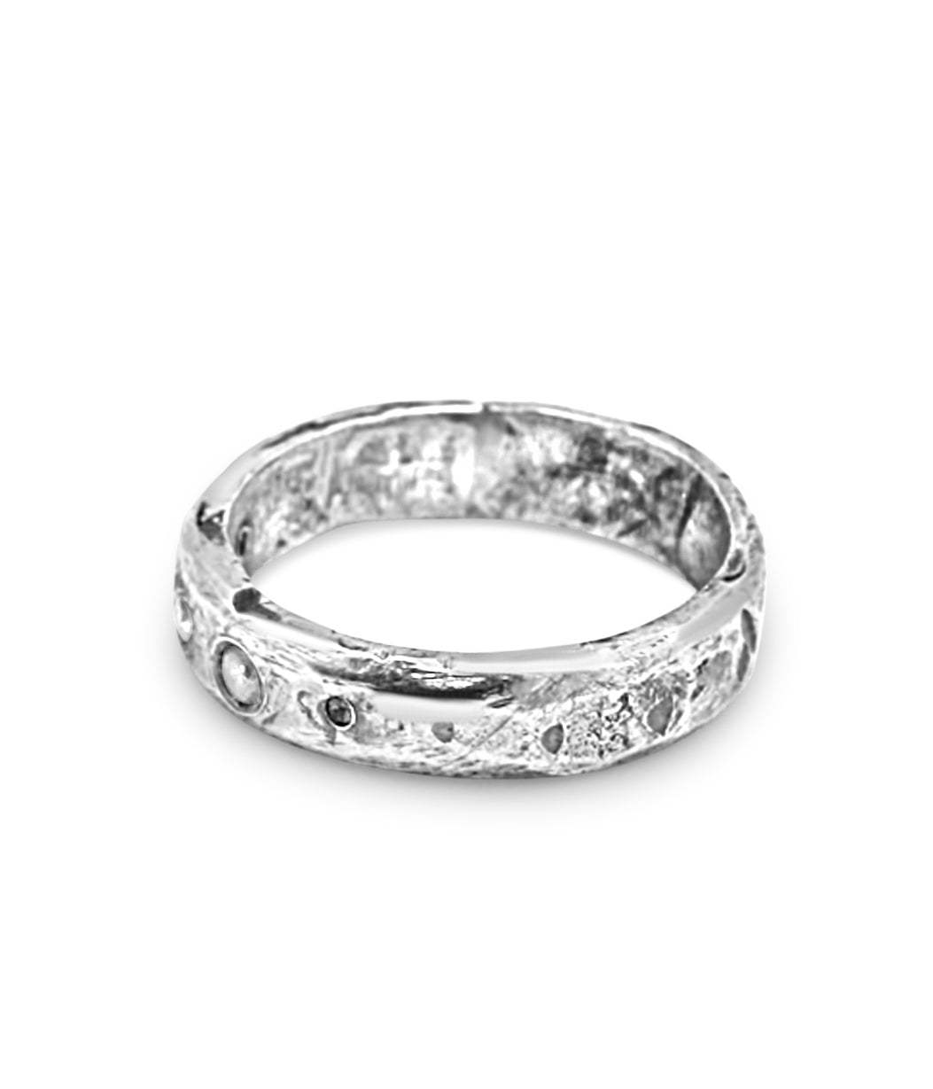 Silver ring with a textured band on a white background