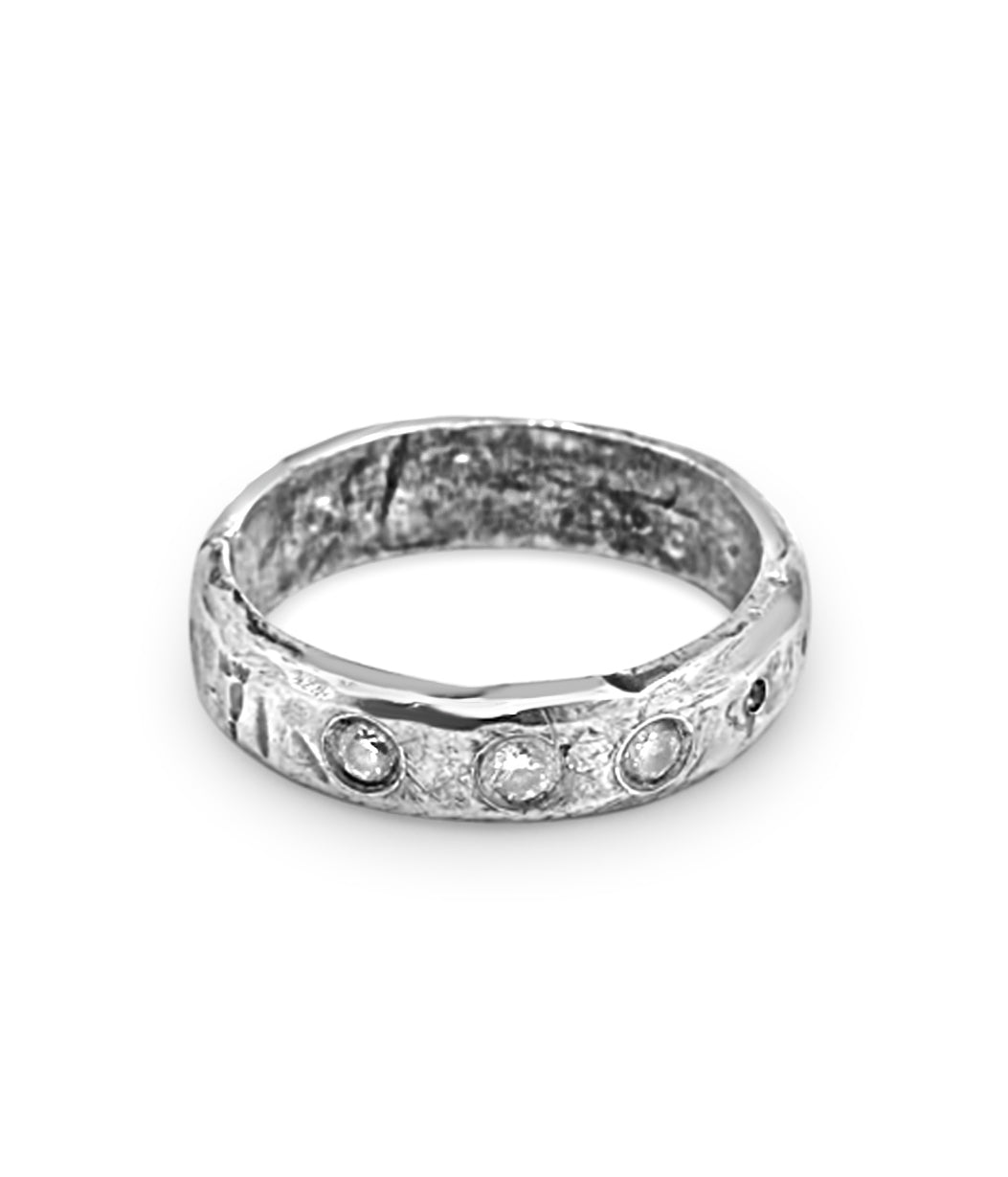 Silver ring with embedded stones on a white background