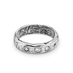Silver ring with embedded stones on a white background