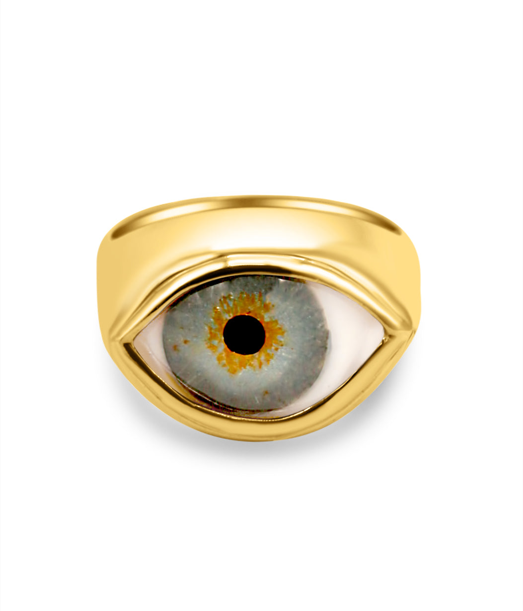 Gold ring with an eye design on a white background