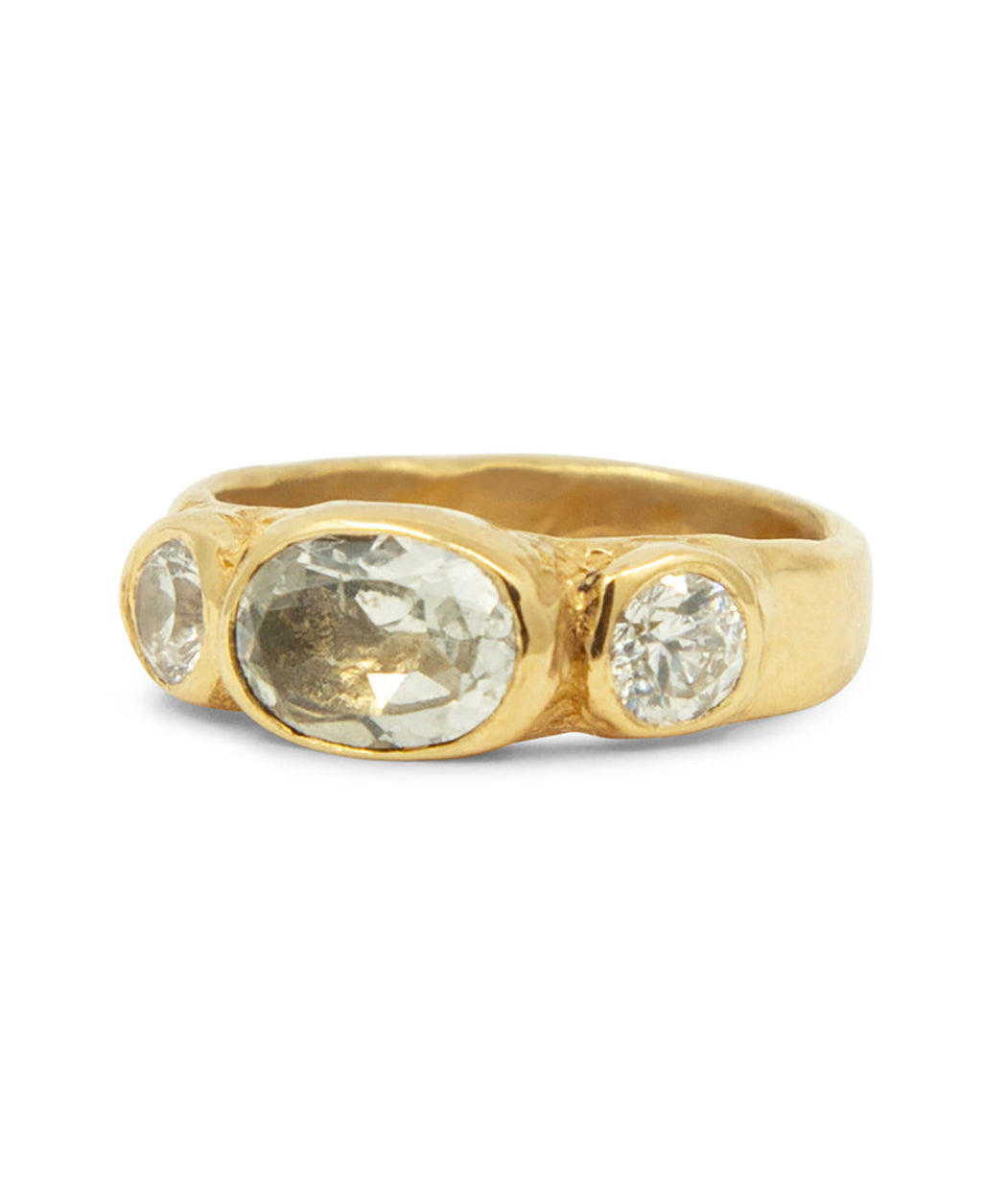 Gold ring with three clear gemstones on a white background