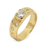 Gold ring with central diamond and smaller diamonds on a white background