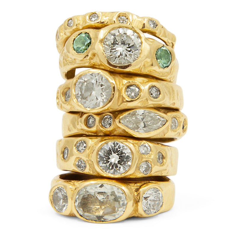 Stack of gold rings with gemstones on a white background