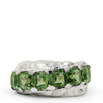 Silver ring with green gemstones on a white background