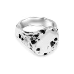 Silver ring with black speckles on a white background