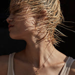 Woman with wet hair blowing in the wind against a dark background