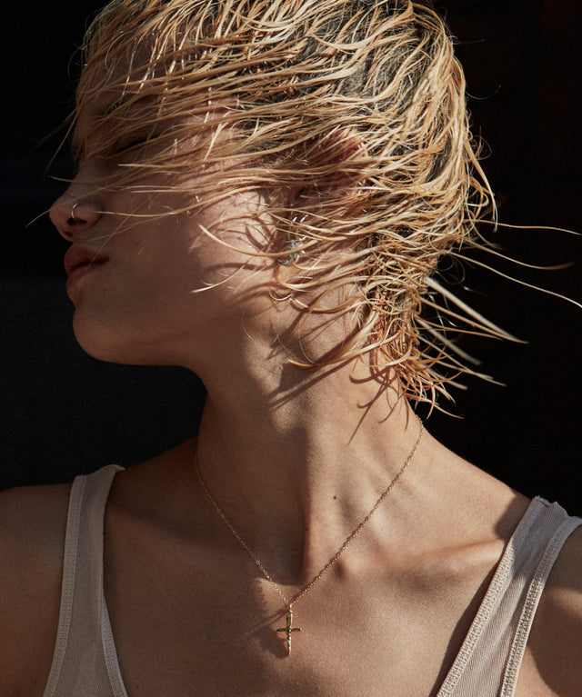 Woman with wet hair blowing in the wind against a dark background