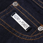 Close-up of a denim fabric with 'Agony of Power' label.