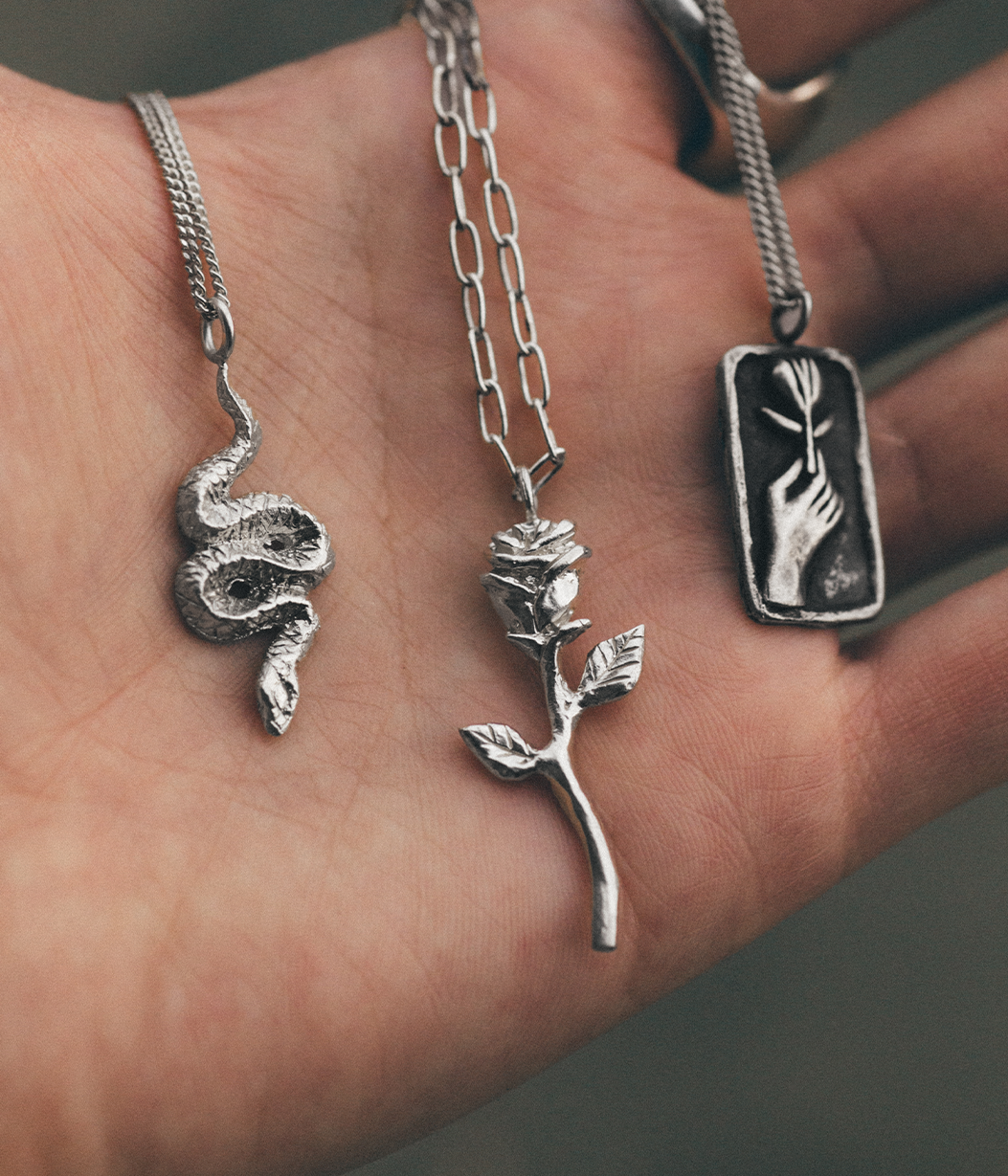 three silver chains in hand 
