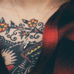 snake pendant necklace on tattooed chest