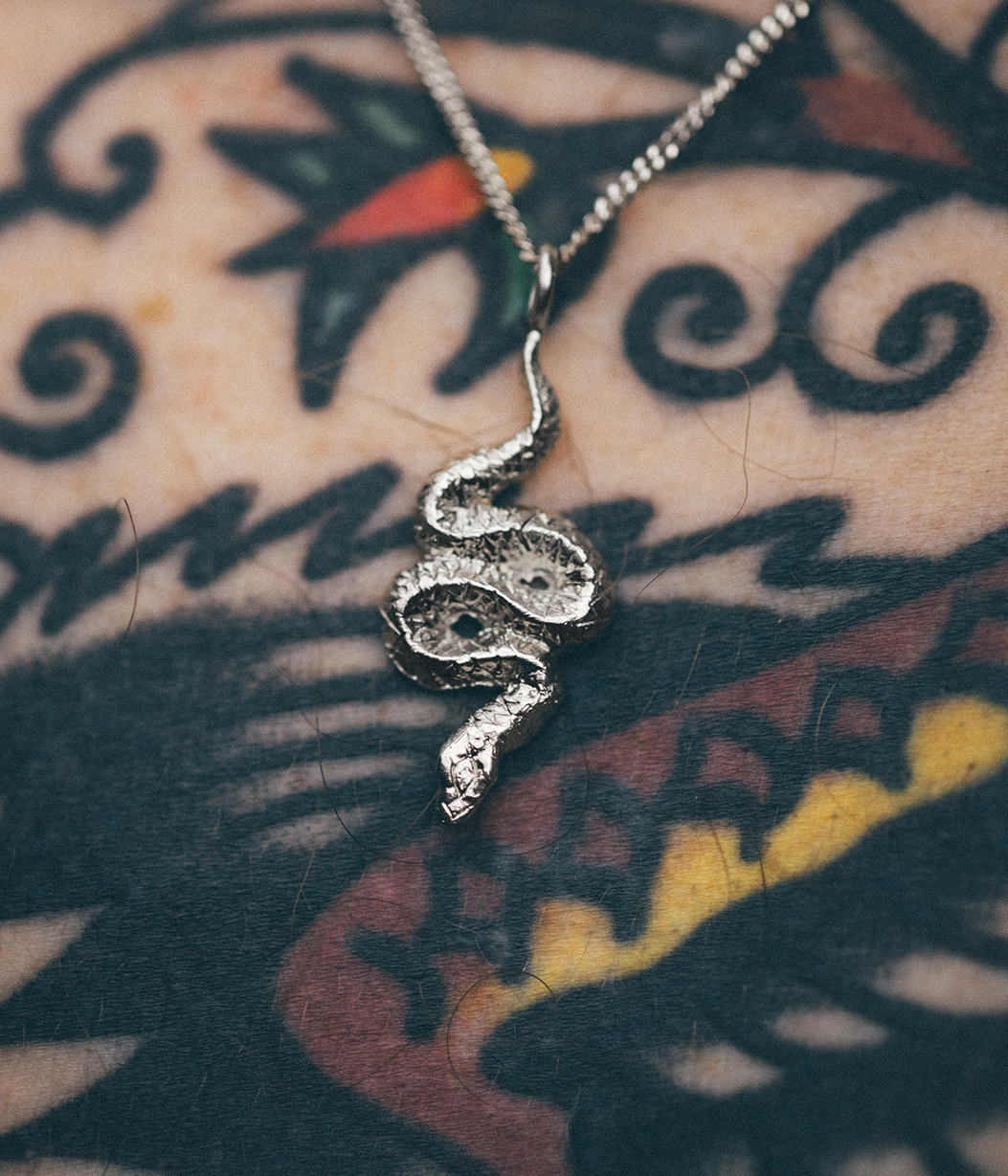 snake pendant on tattooed skin
