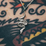 snake pendant on tattooed skin