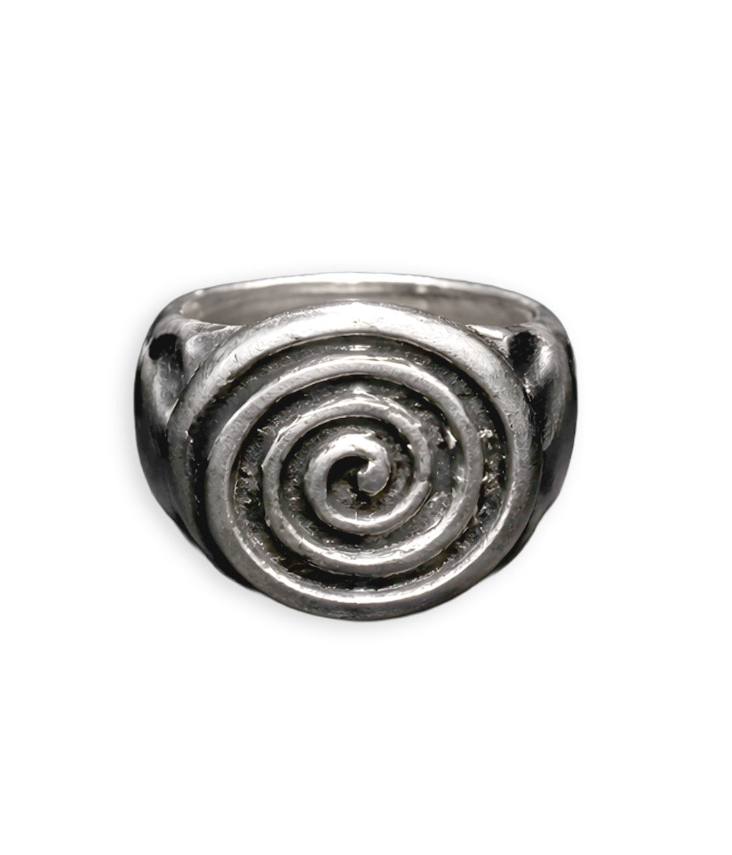A silver-toned signet ring featuring a raised spiral design on the face, photographed against a plain white background.
