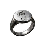 A silver signet ring featuring engraved crescent moon and star symbols on the top, shown against a plain white background.