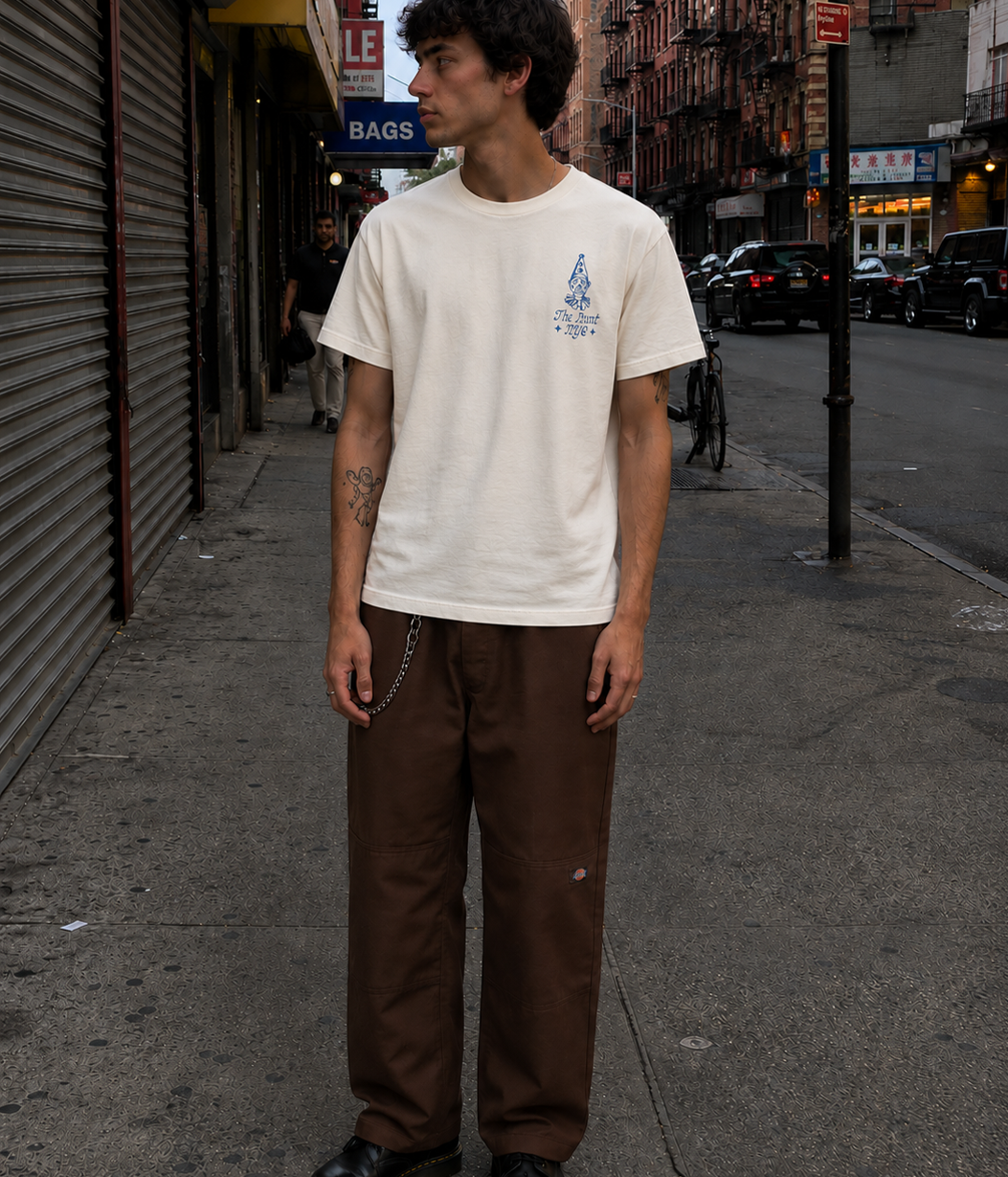 Man wearing a white t-shirt with a graphic design on a city street.
