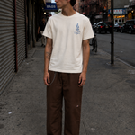 Man wearing a white t-shirt with a graphic design on a city street.